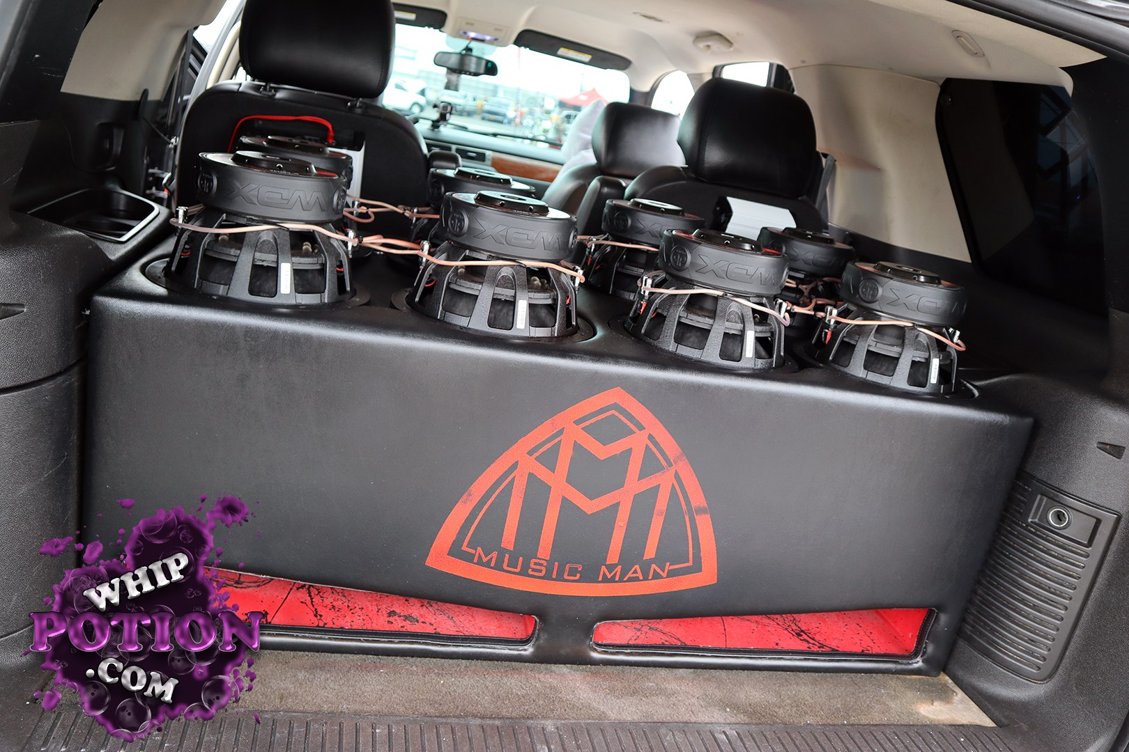 This SUV’s cargo area is converted into a serious bass wall, with a custom enclosure packed with eight large subwoofers and clean black trim that keeps the setup looking sharp. The “Music Man” logo on the box adds a personal touch, and the rear seats are still in place, which makes the whole build feel like a well-planned daily that can still rattle windows when it wants to.