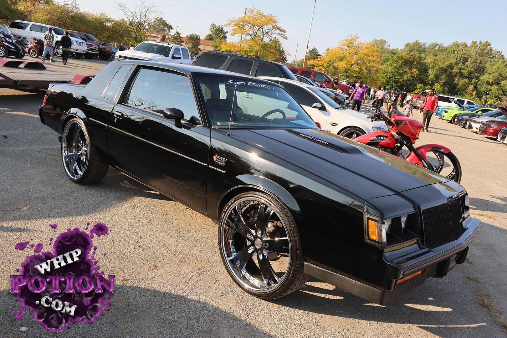 A clean black Buick Grand National with a hardtop profile and unmistakable turbo V6 badging, sitting on big polished billet wheels that give it a modern street-machine edge. The glossy paint, dark tint, and squared-off GN nose keep the car’s menace intact, while the shaved, tidy look shows real care in the build.