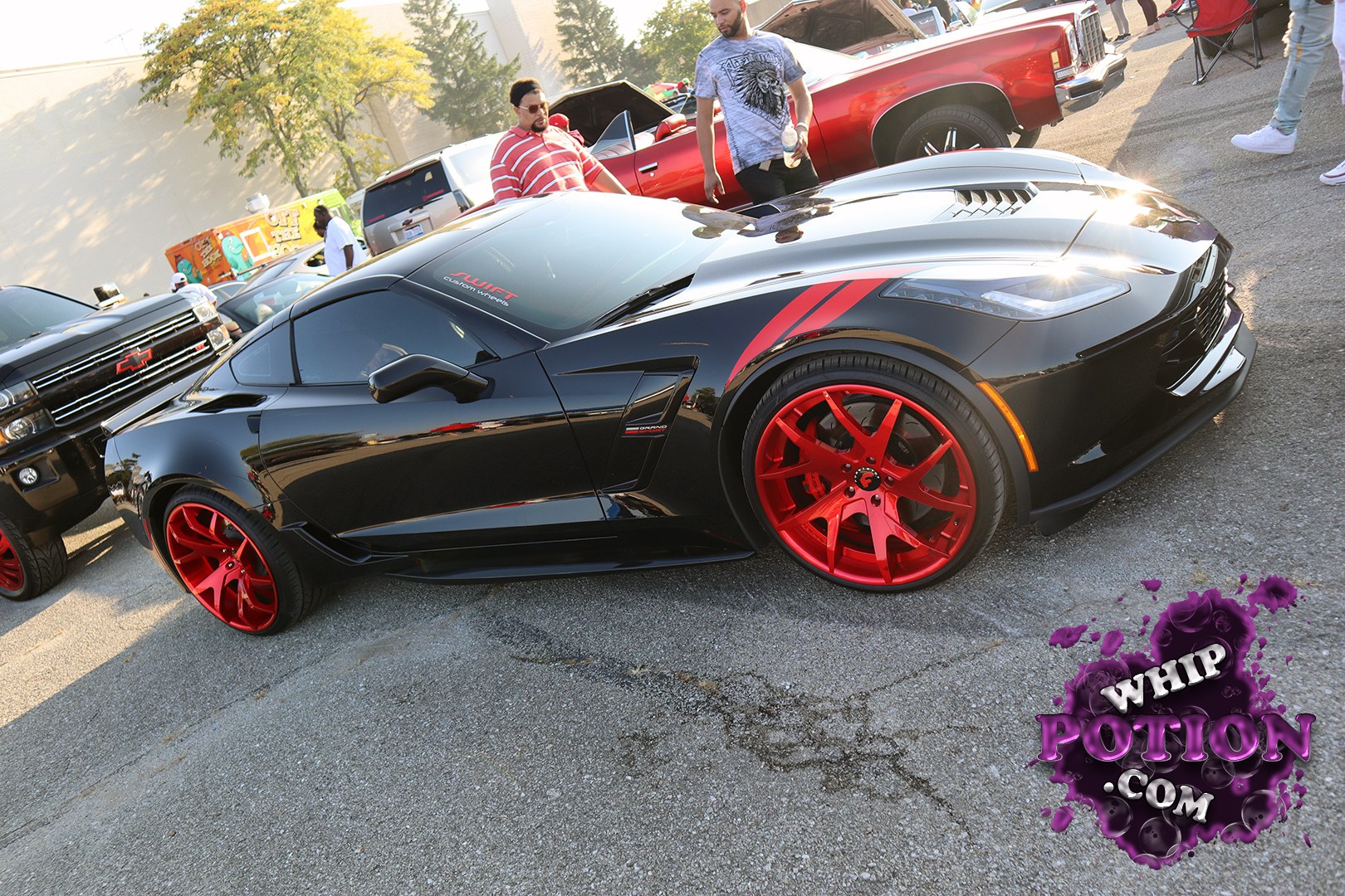 This black Chevrolet Corvette looks wickedly dialed-in, with a sharp contrast from the bright red multi-spoke wheels and matching accent stripes on the fenders. The low, wide stance and the vented hood give it a more aggressive, street-ready attitude, while the tinted glass and clean body lines keep the build focused and purposeful.