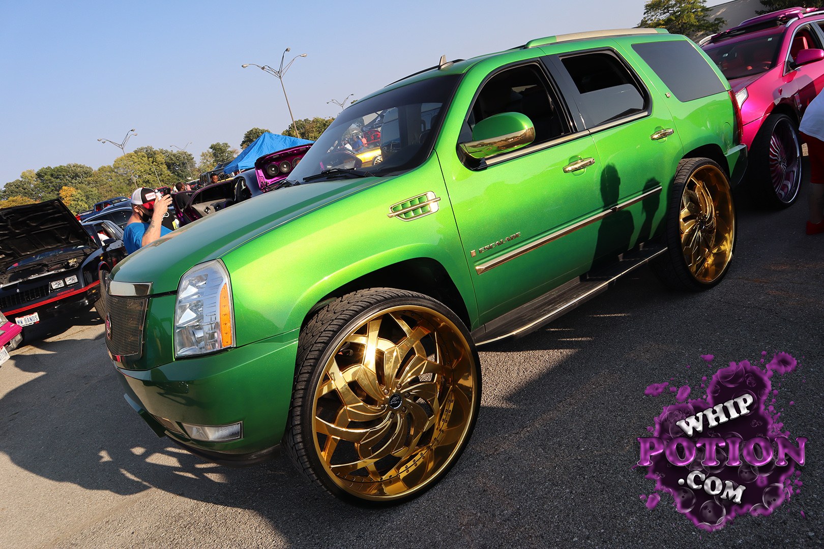 A bright green Cadillac Escalade sits on oversized gold multi-spoke wheels, giving the big SUV a flashy custom look without going overboard on the bodywork. The tinted glass, chrome trim, and clean paint let those deep-dish rims do the talking, while the stance keeps it looking more show-cruiser than off-road rig.