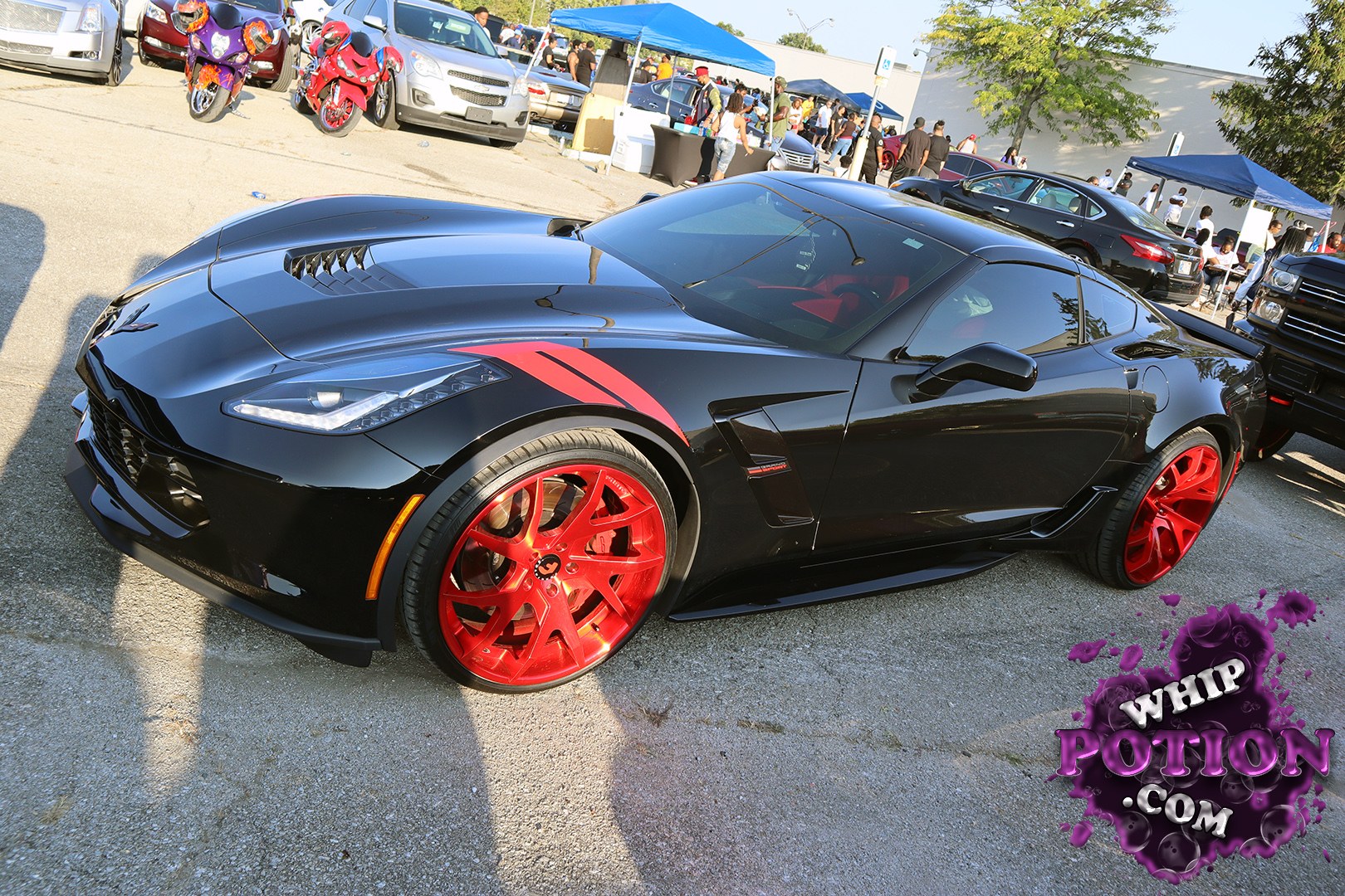 A black Chevrolet Corvette Z06 sits low and mean, its long hood and wide hips instantly giving away the C7 shape. The red Vossen-style wheels and matching accent graphics add a sharp contrast, while the dark tint and aggressive aero keep the car looking purpose-built. It’s a clean, street-ready setup with just the right amount of flash.