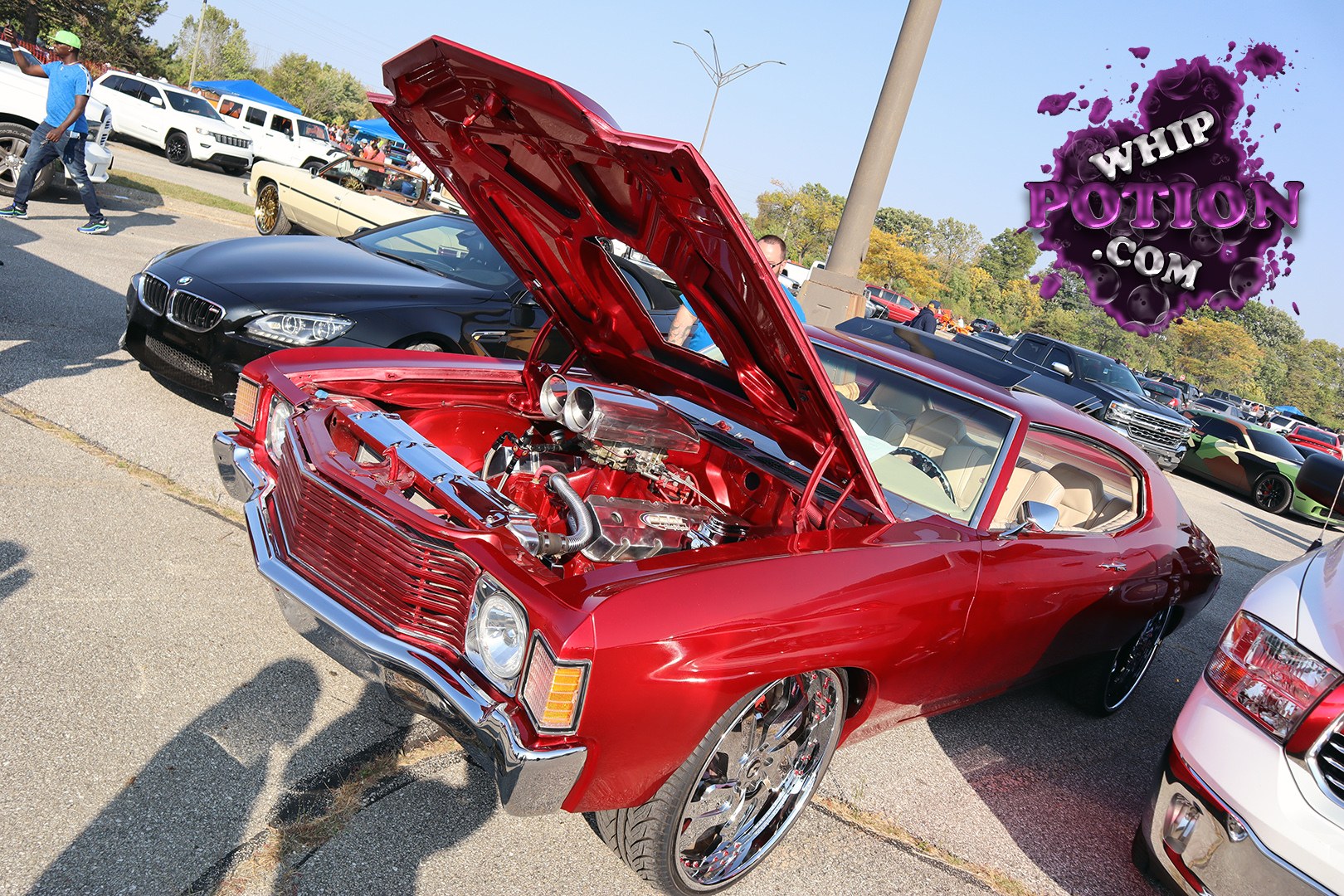 This red classic Chevy coupe is built to be seen, with the hood flipped up to expose a polished V8 and a tidy, body-colored bay. The chrome grille and bumper keep the old-school look intact, while the big mirrored wheels and low stance give it a clean custom attitude. Beige interior and shaved-looking lines finish it off nicely.