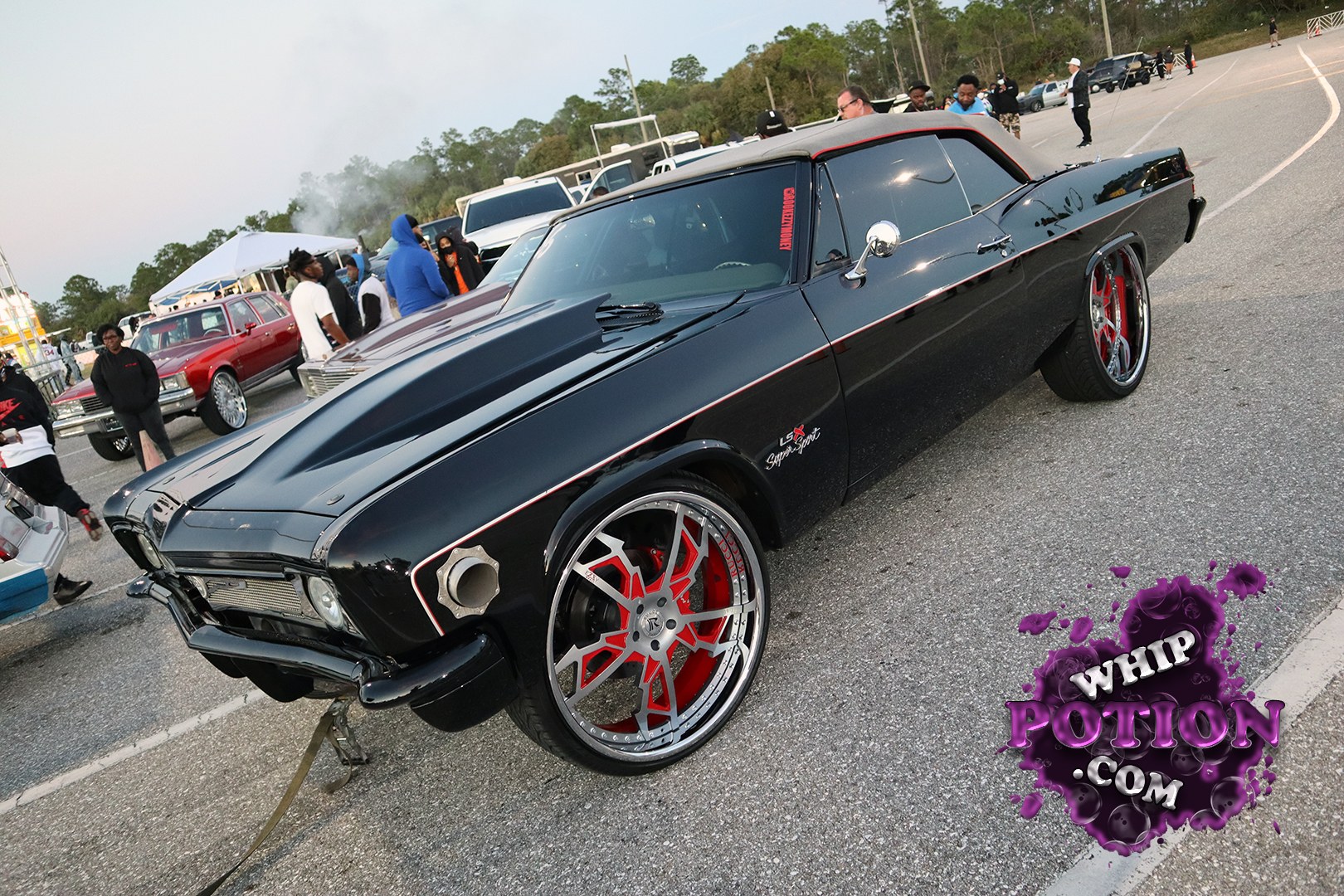 This black Dodge Charger wears a wicked pro-touring look with a satin black hood, shaved-down trim, and huge red-and-chrome billets that fill the arches perfectly. The stance is aggressive without going cartoon-low, and the “LSX Super Sport” fender badge hints at the serious swap under the hood. The red-accented roof and clean body lines give it real old-school muscle with a modern edge.