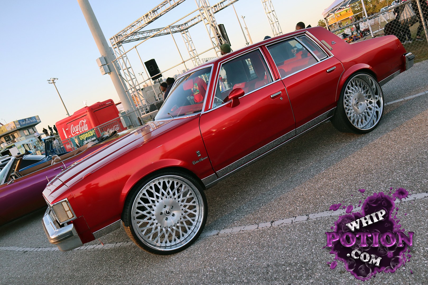 This early-’80s Chevrolet Malibu gets a clean grand-dad cruising treatment in deep red, with chrome trim, a squared-off profile, and massive multi-spoke wheels tucked under the fenders. The stance is dialed in just right, giving the car a classy, low-slung look without going overboard. A tidy, period-correct build with real street presence.