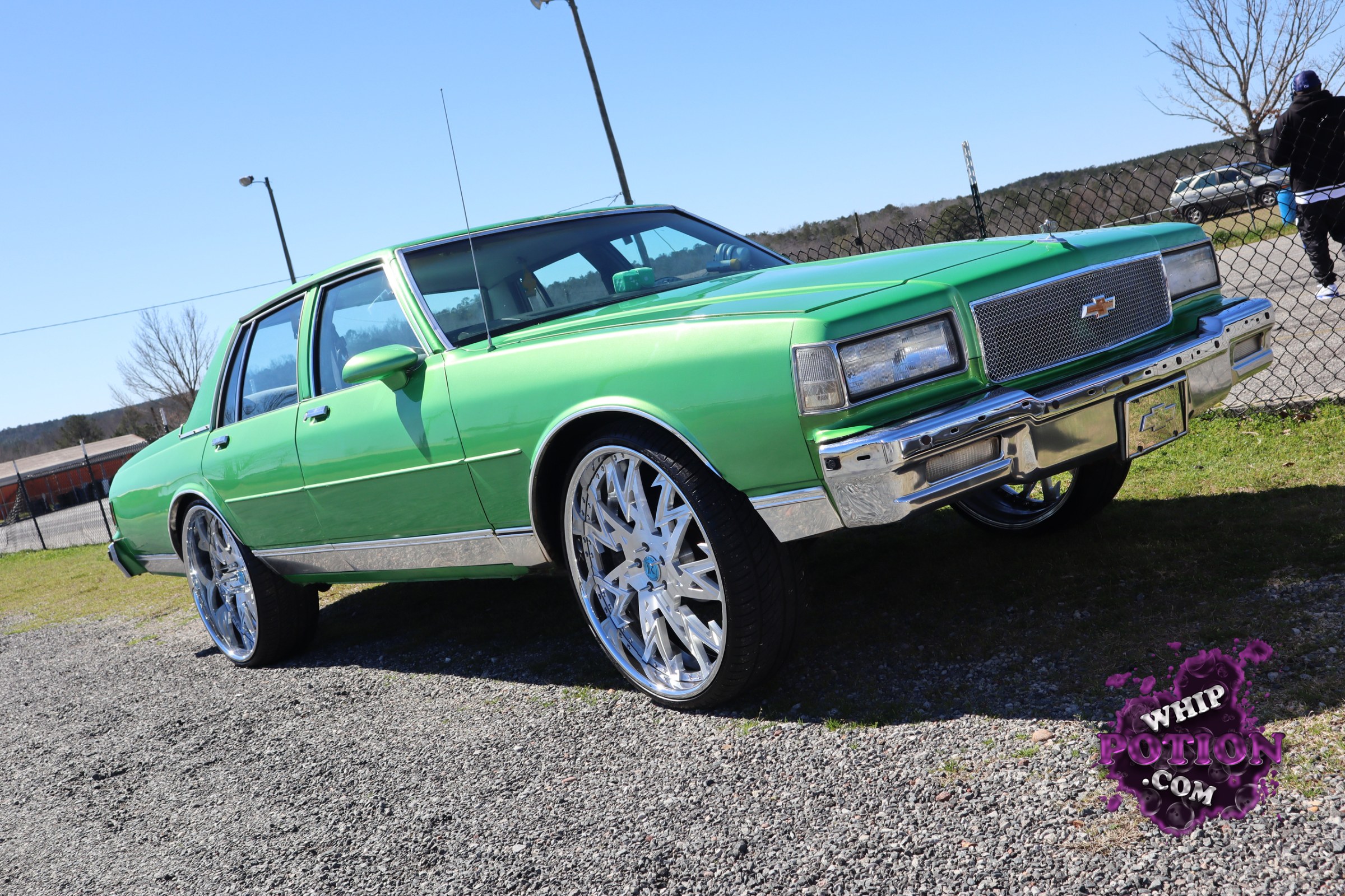 This classic Chevrolet sedan is finished in a wild lime green that makes the chrome really pop, and the big billet-style wheels fill the wells with serious presence. The mesh grille with the Chevy bowtie, clean body lines, and glossy trim give it a crisp custom look, while the tall stance and oversized rolling stock lean into a bold, show-ready style.