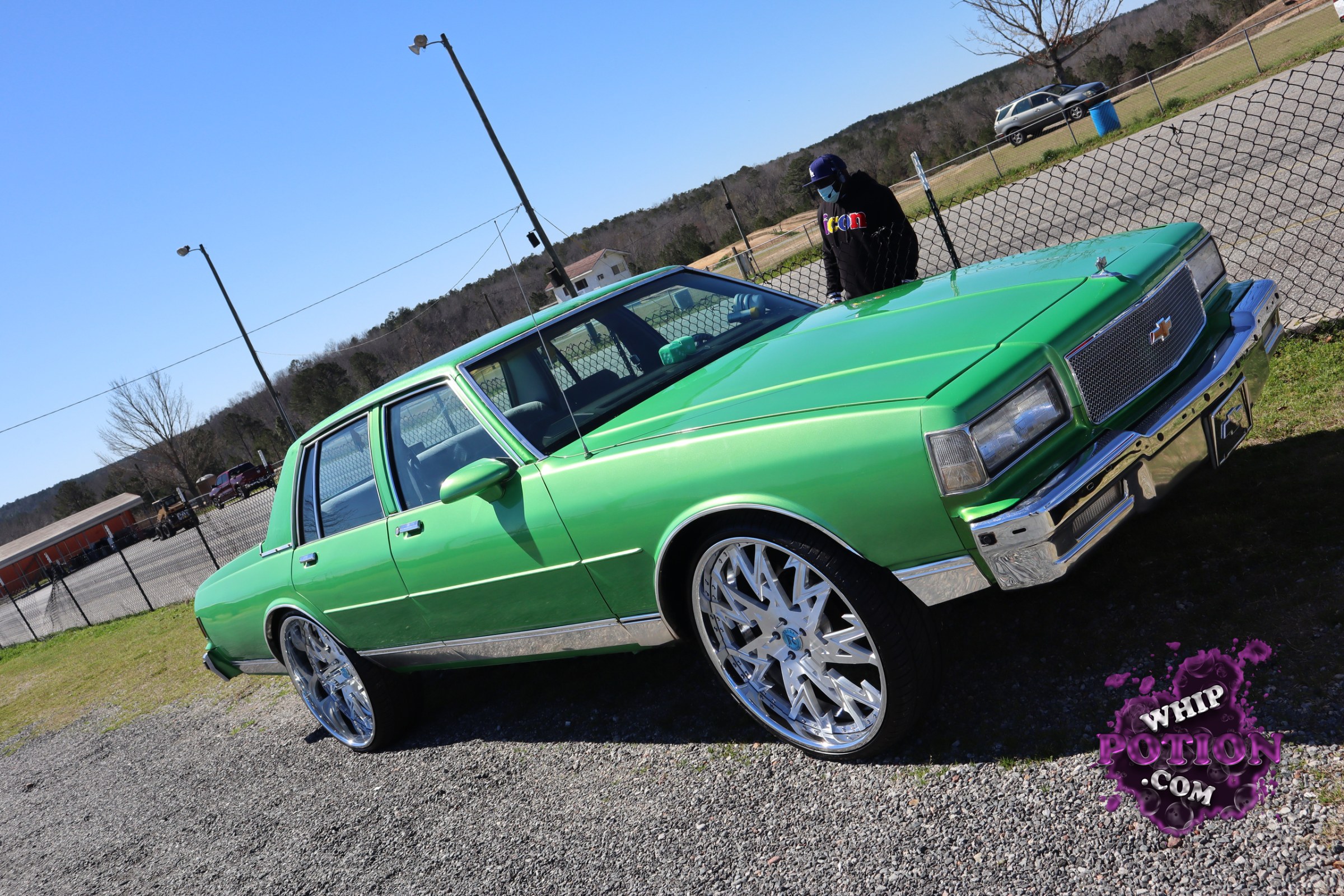 This bright green Chevrolet Caprice sedan has a clean, old-school look with a fresh metallic finish, chrome trim, and a mesh grille that suits the squared-off body nicely. The big polished wheels and low, level stance give it a polished custom presence without going overboard.