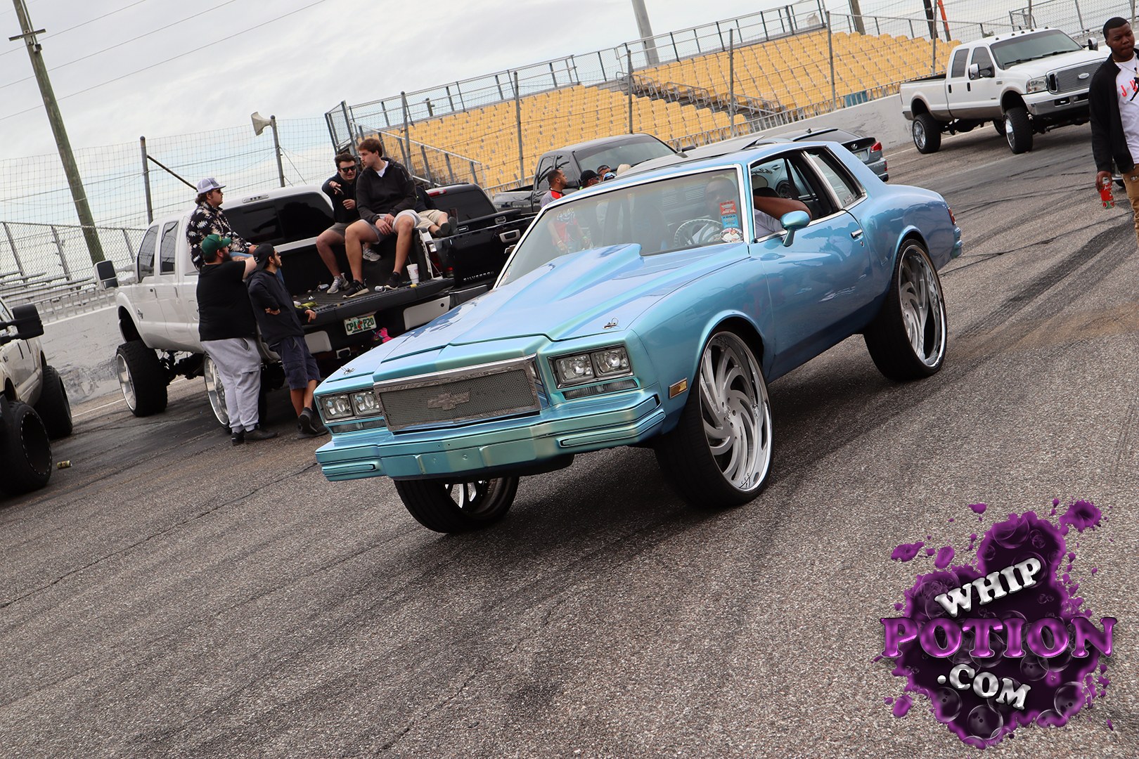 This classic two-door Chevy coupe wears a slick baby-blue finish, a chromed mesh grille, and oversized polished wheels that give it a serious pro-touring stance. The lowered front end and clean body lines keep the look sharp, while the custom interior peeking through the glass hints at a well-sorted build with plenty of attitude.