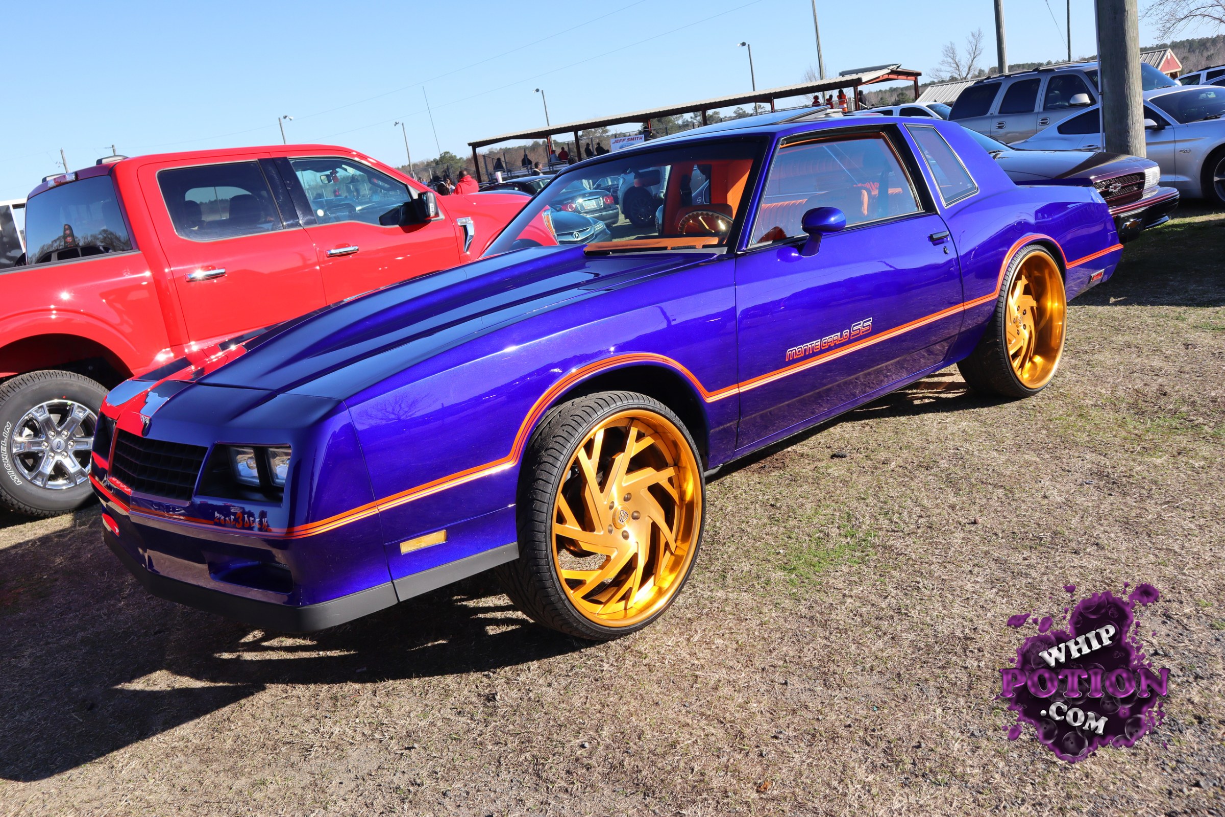 This Pontiac Monte Carlo SS wears a vivid purple finish with orange striping and oversized gold wheels that give it a bold pro-street flavor. The clean bodywork, dark grille, and tailored two-door profile keep the classic G-body shape front and center, while the bright interior trim adds just enough contrast to make the build feel deliberate and well sorted.