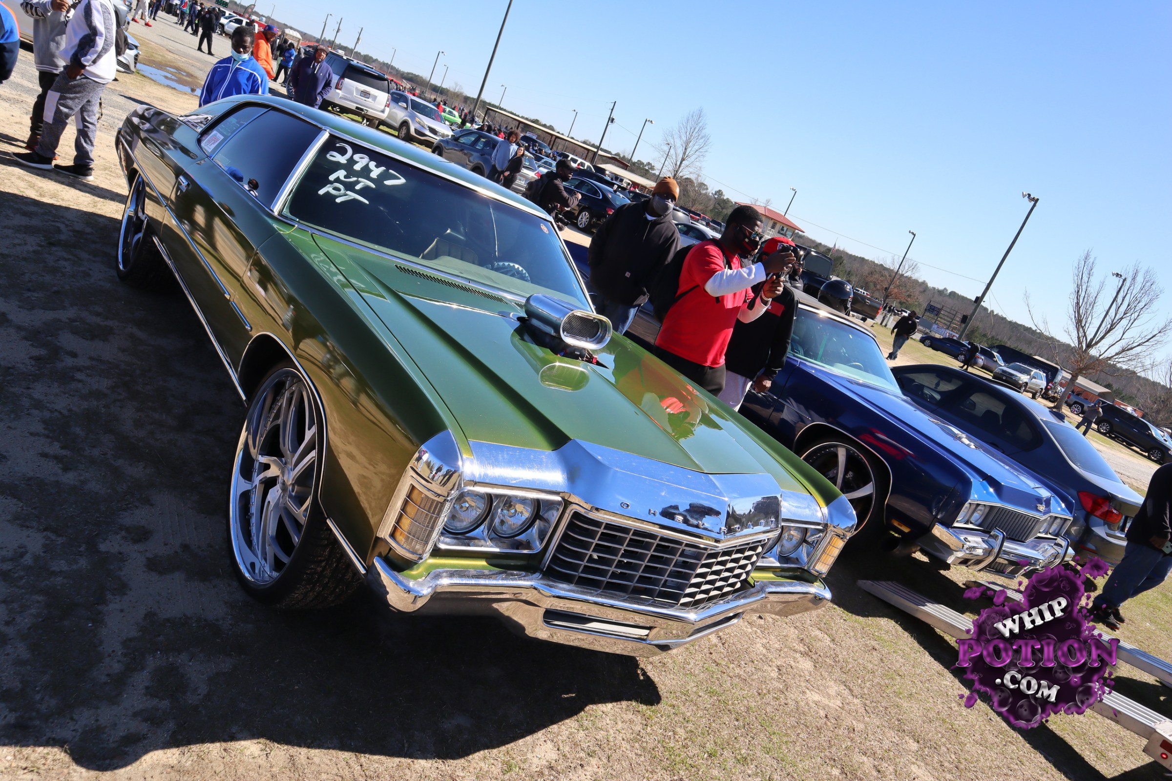 This classic Chevrolet coupe wears a deep metallic green finish with plenty of chrome flash, from the square grille and bumper to the mirror-like hood scoop sitting proud out front. Big polished wheels fill the wells, giving it a clean pro-street vibe, while the dark-tinted glass and shaved-looking bodywork keep the whole build looking tight and serious.
