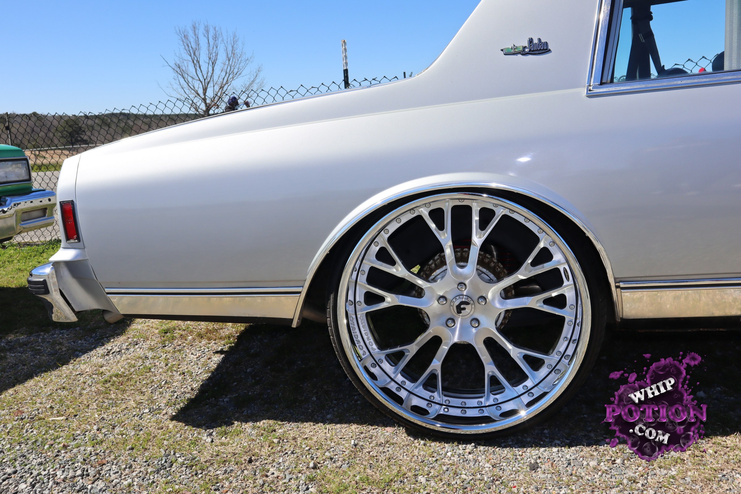 The fastback profile and vent-window trim point to an old-school Chevrolet Monte Carlo, laid out with a smooth silver finish and serious big-diameter billet-style wheels tucked tight under the arches. It’s a clean, street-cruiser build with just the right rake, polished trim, and a classic GM silhouette that still looks mean from the side.