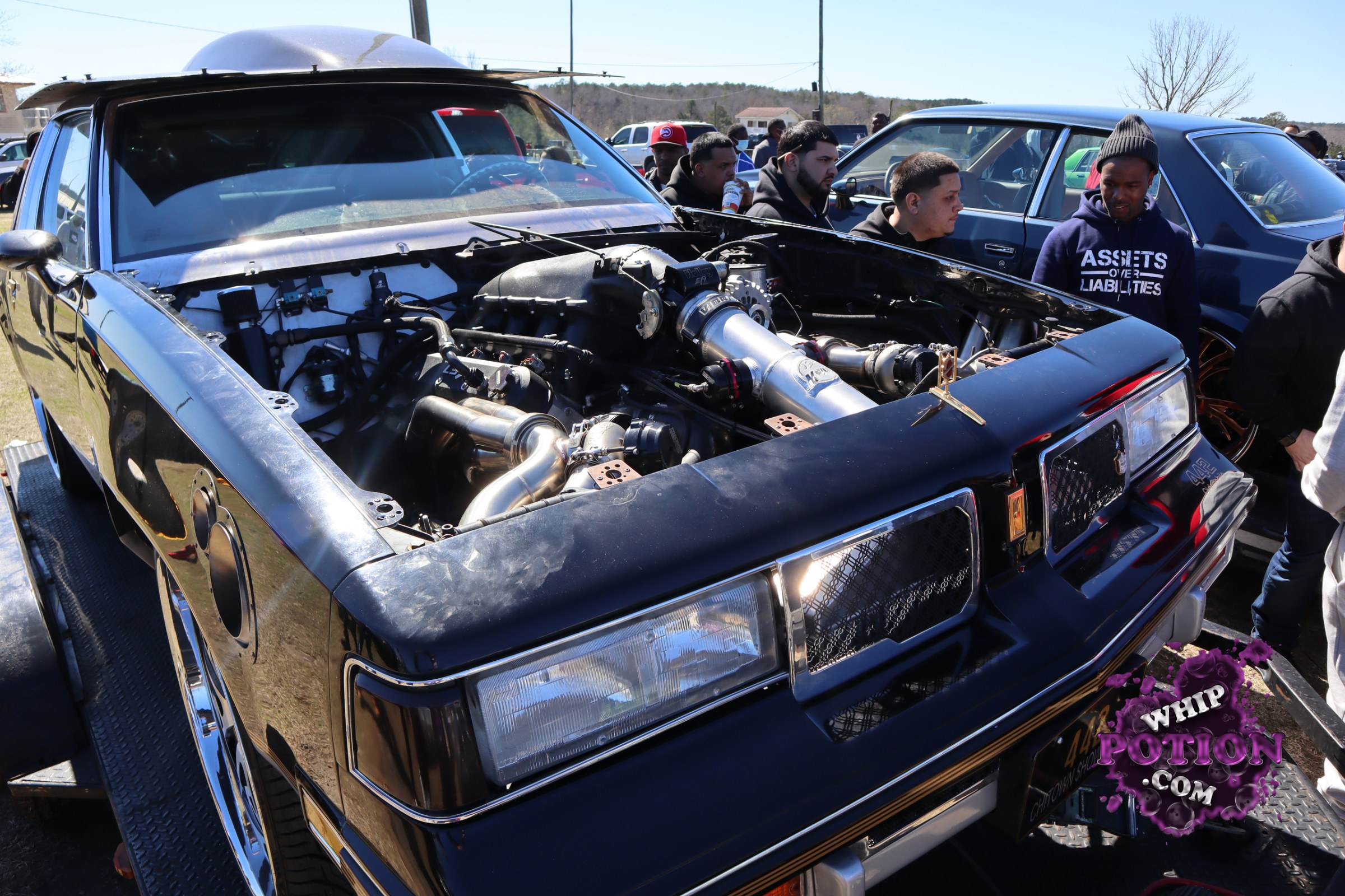 This black Buick Regal has been turned into a serious pro-street-style build, with the front clip removed to show off a wild twin-turbo setup stuffed into the bay. The squared-off body, chrome trim, and factory-style nose still give it that classic G-body attitude, but the polished plumbing and deep stance say this one was built to run hard.