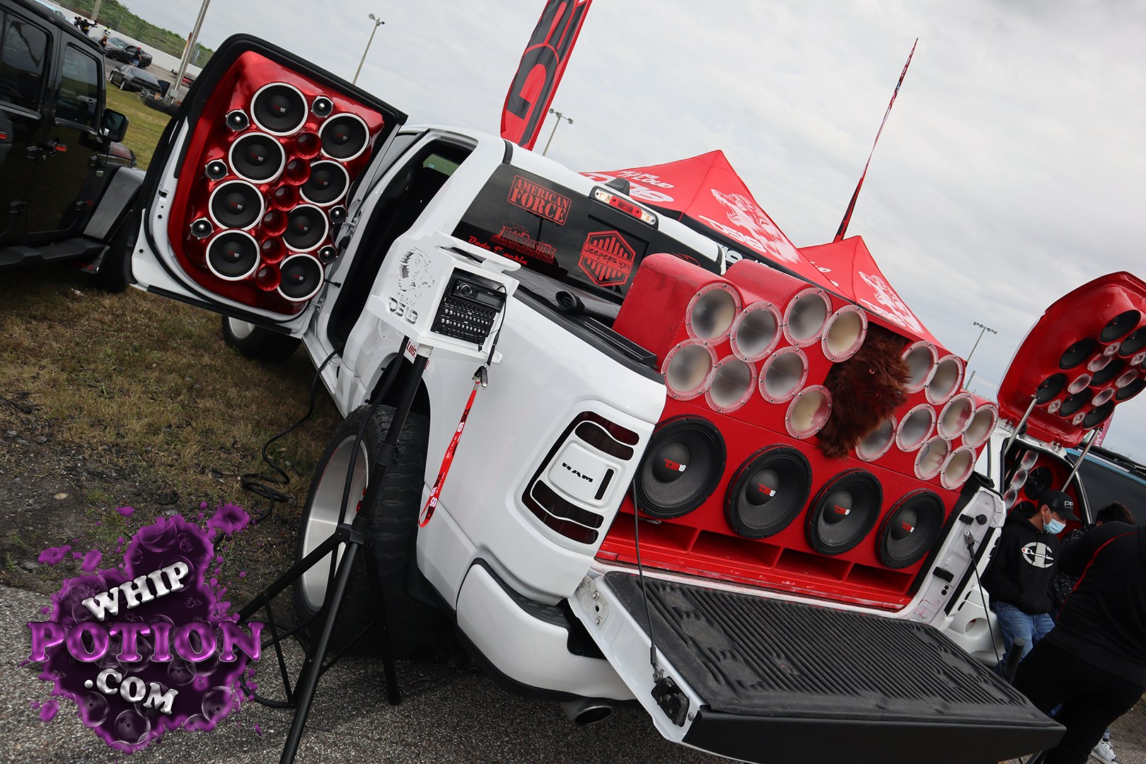 This RAM pickup is built like a rolling sound wall, with the tailgate and both rear doors packed full of speakers, plus more drivers mounted in the bed and on the open rear panel. The white-and-red custom theme, oversized audio hardware, and aggressive show-truck stance make it clear this one was engineered to be heard before it’s even noticed.