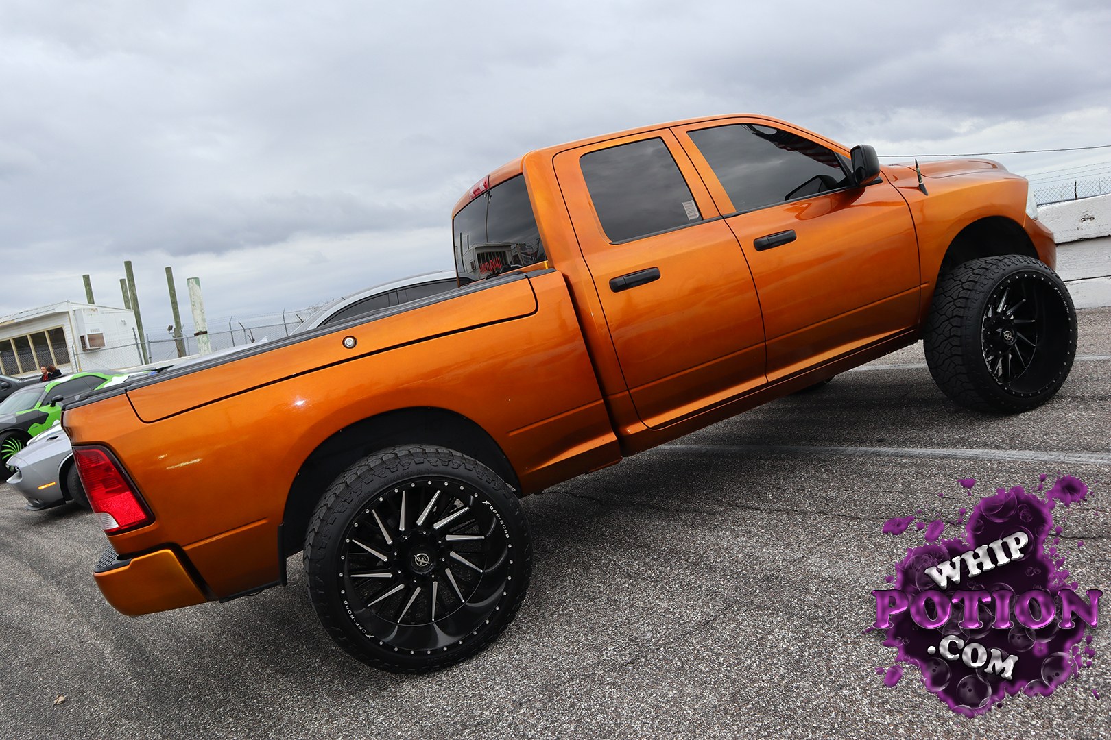 This lifted Ram 1500 crew cab wears a deep burnt-orange finish that really plays off the blacked-out trim, tinted glass, and oversized black multi-spoke wheels. The stance is tall and purposeful, with meaty off-road tires filling the arches and giving the truck a clean custom look that mixes show flair with a little attitude.