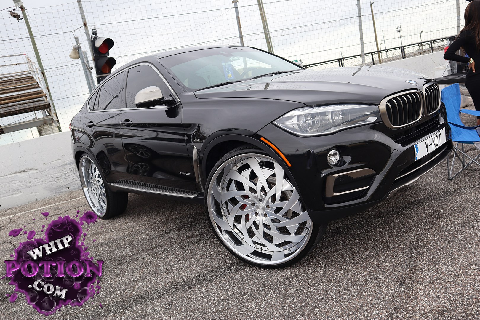 This BMW X6 sDrive35i wears a deep gloss-black finish with a sleek, coupe-like SUV profile and a very custom wheel setup that really changes the attitude. The oversized polished multi-spoke rims fill the arches nicely, while the tinted glass, clean bodywork, and factory trim keep the build looking sharp without overdoing it.