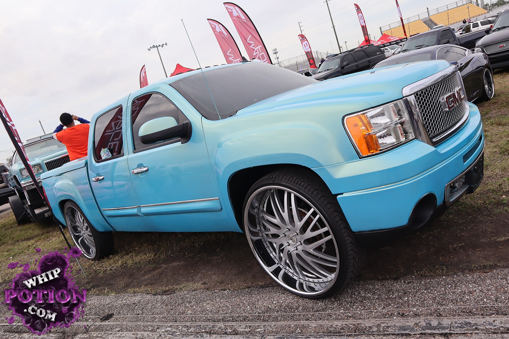 This GMC Sierra has been dressed up with a slick two-tone blue fade, big chrome mesh grille, and oversized multi-spoke wheels that fill the wells nicely. The stance sits low and clean without going overboard, and the shaved-look paint and tinted glass give it a smooth, custom street-truck vibe.