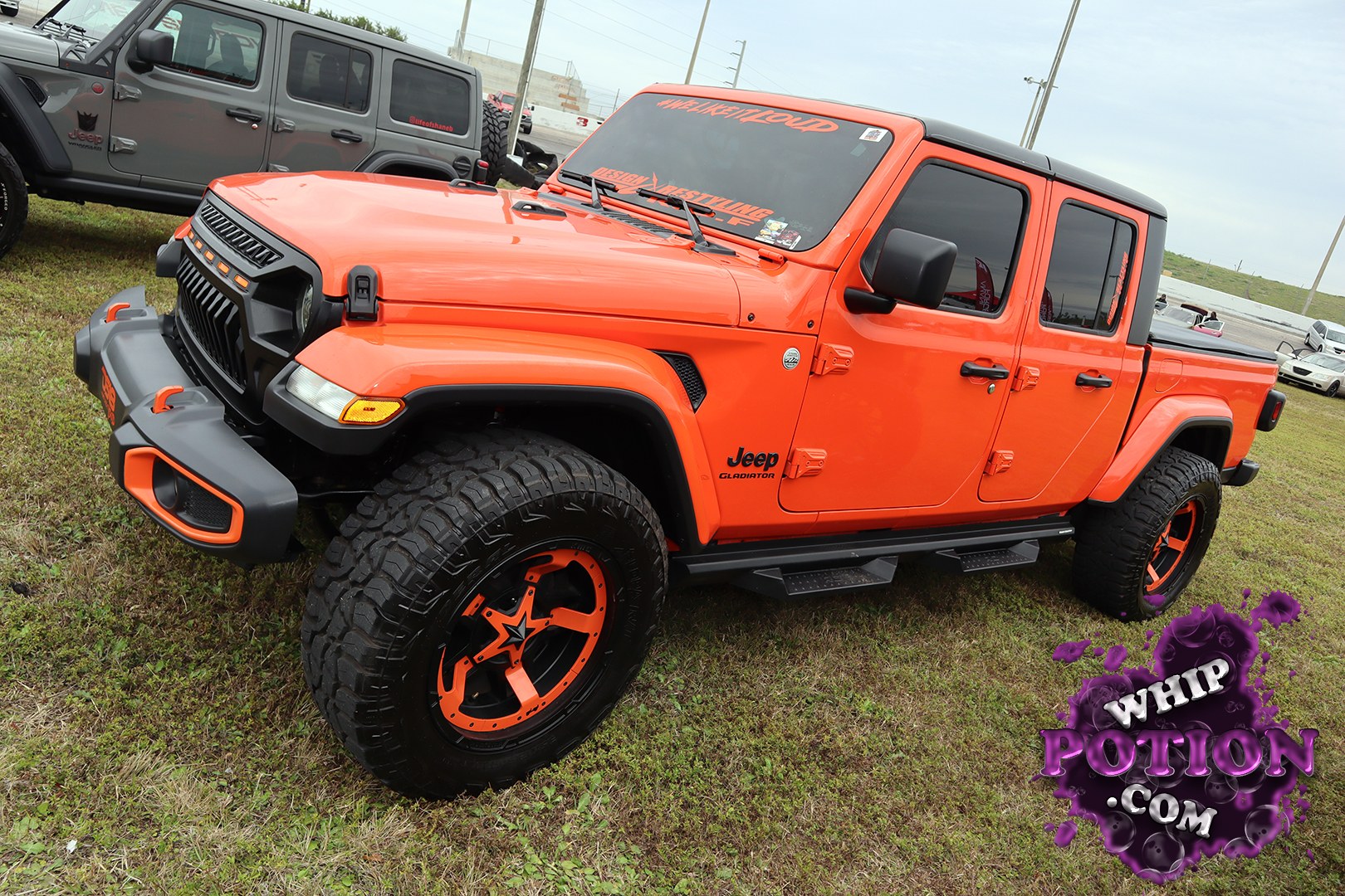 This Jeep Gladiator wears a loud orange-and-black combo that fits the build perfectly, with a tough lifted stance, chunky off-road tires, and custom deep-dish wheels that lean hard into the street-truck-meets-trail look. Blacked-out trim, tinted glass, and the matching accents on the bumper and grille give it a clean, well-planned finish.